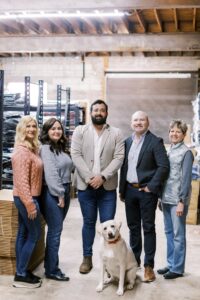 The Steinberg Sportswear Team poses in their Albany warehouse