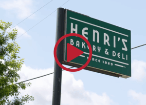 Green sign that says "Henri's Bakery and Deli Since 1929"