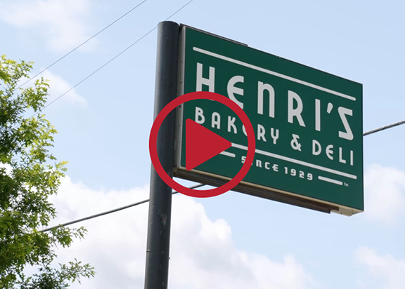 Green sign that says "Henri's Bakery and Deli Since 1929"